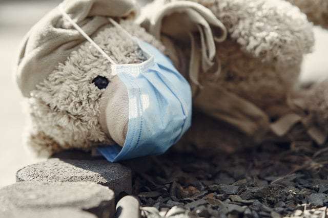 lost-teddy-toy-in-protective-mask-lying-on-pavement-alone-4000608